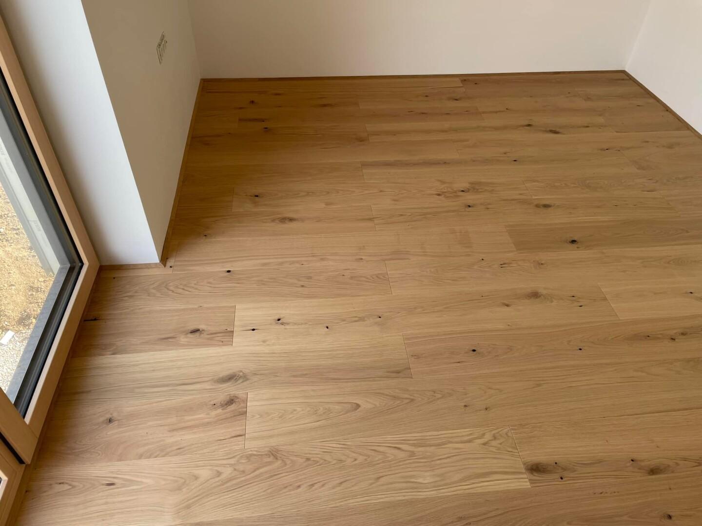 Gotovi parket rustikal Gotovi parket rustikal hrast ob beli steni – naravna hrastova talna obloga z zaključnim profilom