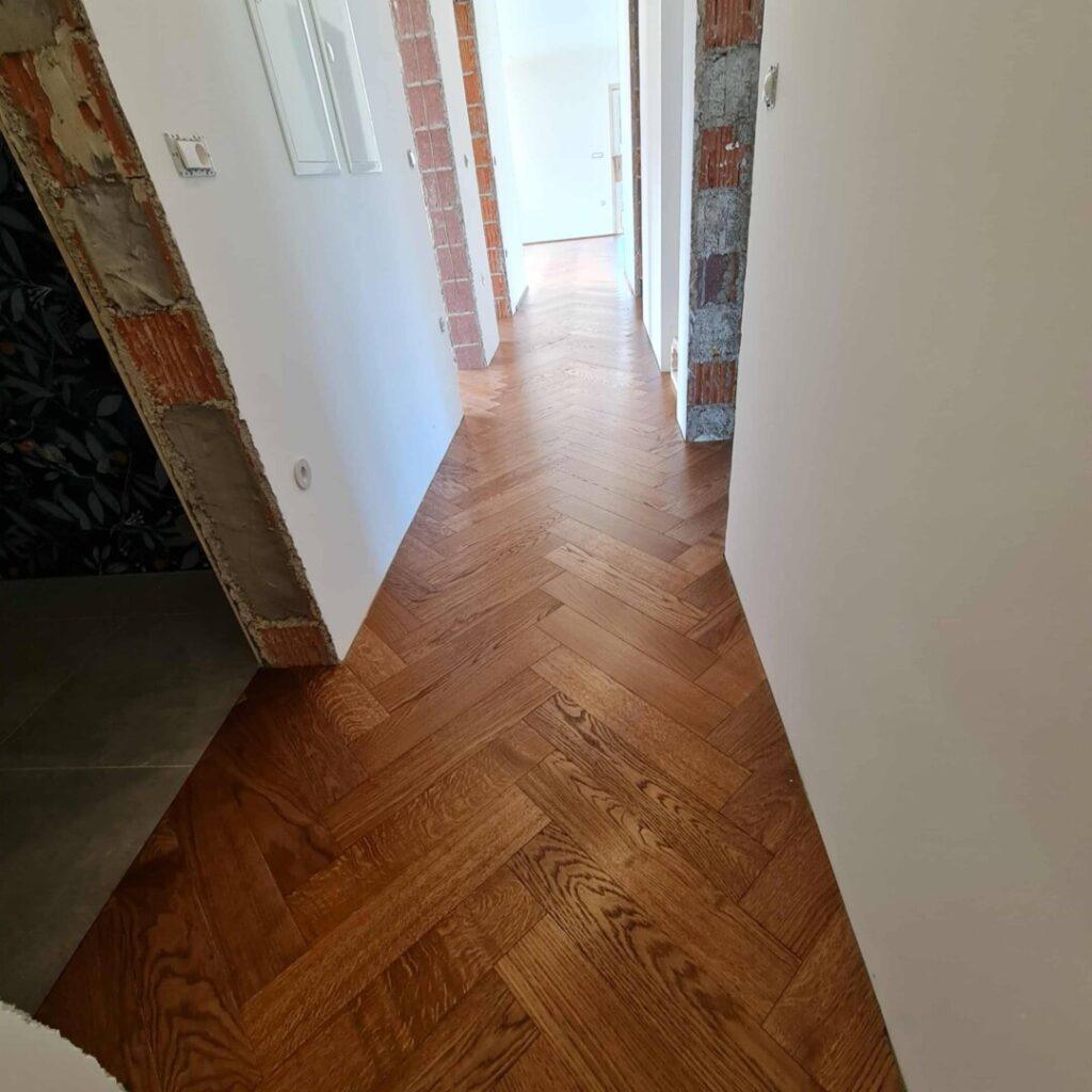 Položen hrastov parket v vzorcu ribje kosti na hodniku